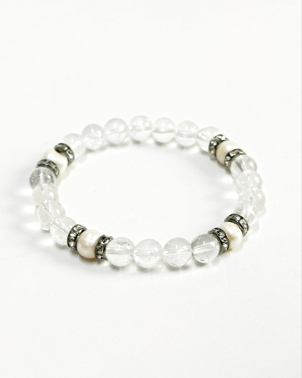 The CIRRUS®️ Quartz & Pearl Bracelet features natural freshwater pearls and clear quartz strung with rhinestone-encrusted spacers in a gunmetal finish.