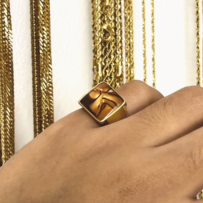 The classic Signet Ring gets a Resin art treatment inspired by the Carnelian stone. Pinky sizes are available for this design. Our rings are made with hypoallergenic stainless steel that goes through high quality Gold PVD plating to ensure your piece lasts up to two years of no fading.